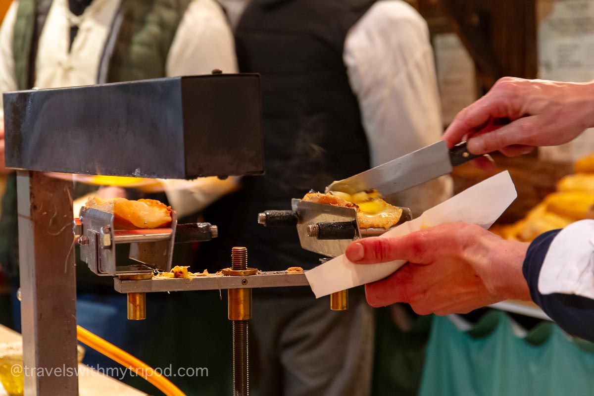 Raclette cheese being served on crusty bread at a Christmas market in Cologne